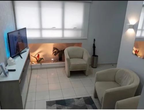 Sala de espera acolhedora do consultório Dr. Ciro Capitani, decoração em tons neutros e ambiente tranquilo